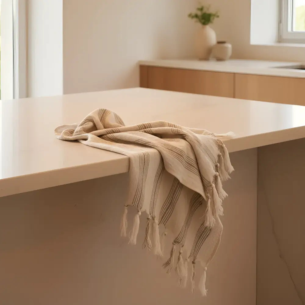 Cream striped tassel towel on white counter