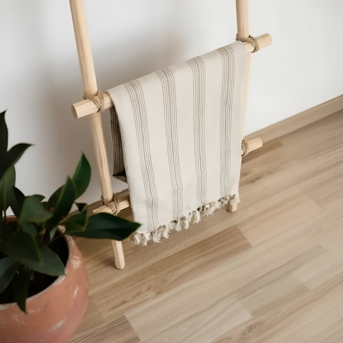 Handwoven natural light brown striped linen cotton Turkish towel on wooden rack