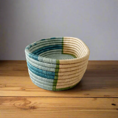 Handwoven sisal bread basket with teal, blue, green, and cream stripes for serving organizing essentials