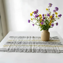 A beige ceramic vase with purple yellow white wildflowers on gorgeous all-natural vetiver placemats set of 6 gray beige stripes