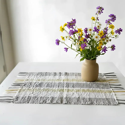 A beige ceramic vase with purple yellow white wildflowers on gorgeous all-natural vetiver placemats set of 6 gray beige stripes