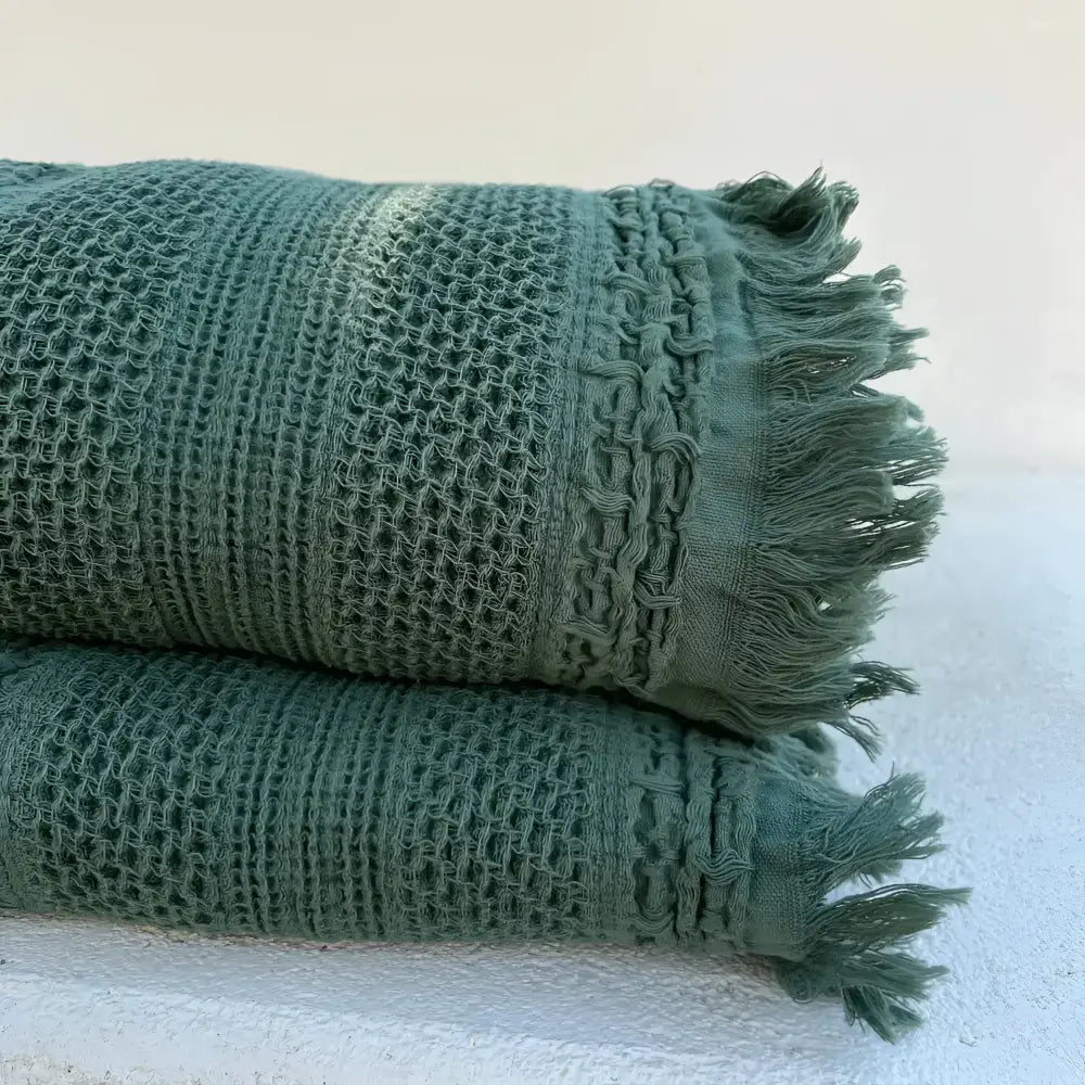 folded green blanket with light background