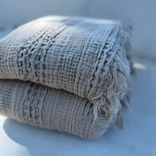 Textured gray blanket folded on light table