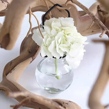 White artificial hydrangea in a hanging rooter glass vase with black metal hanger