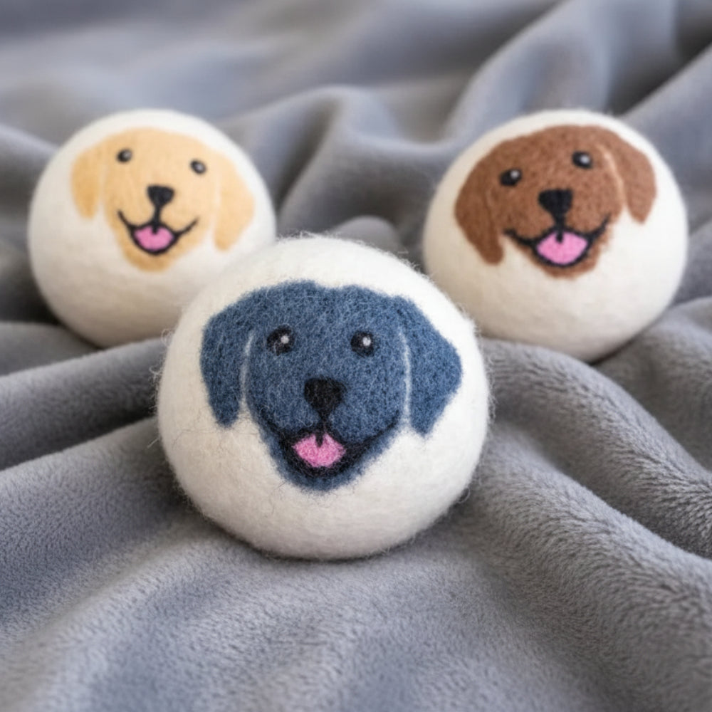 White Happy Dogs eco wool dryer ball with blue yarn dog face
