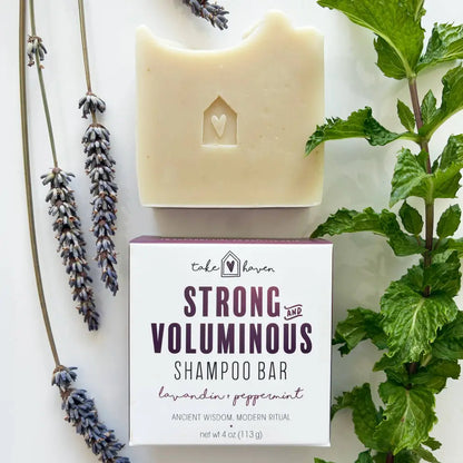Cream-colored herbal shampoo bar with heart cutout on box labeled strong and voluminous infused with nourishing organic oils