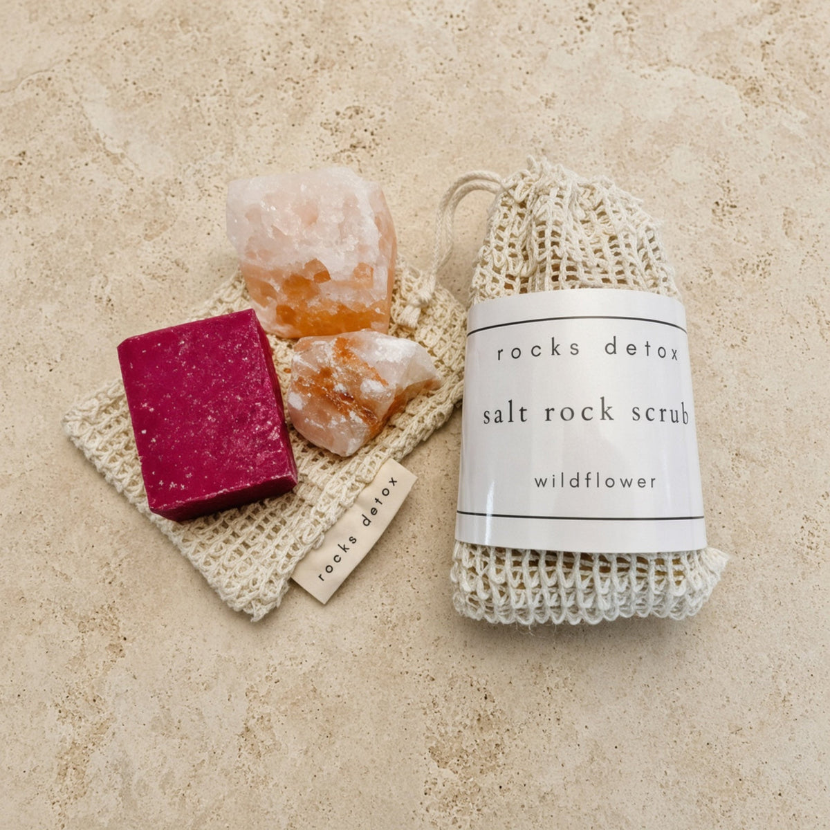 Beige knitted drawstring bag of pink himalayan salt scrub with wildflower scent and handmade organic shea label