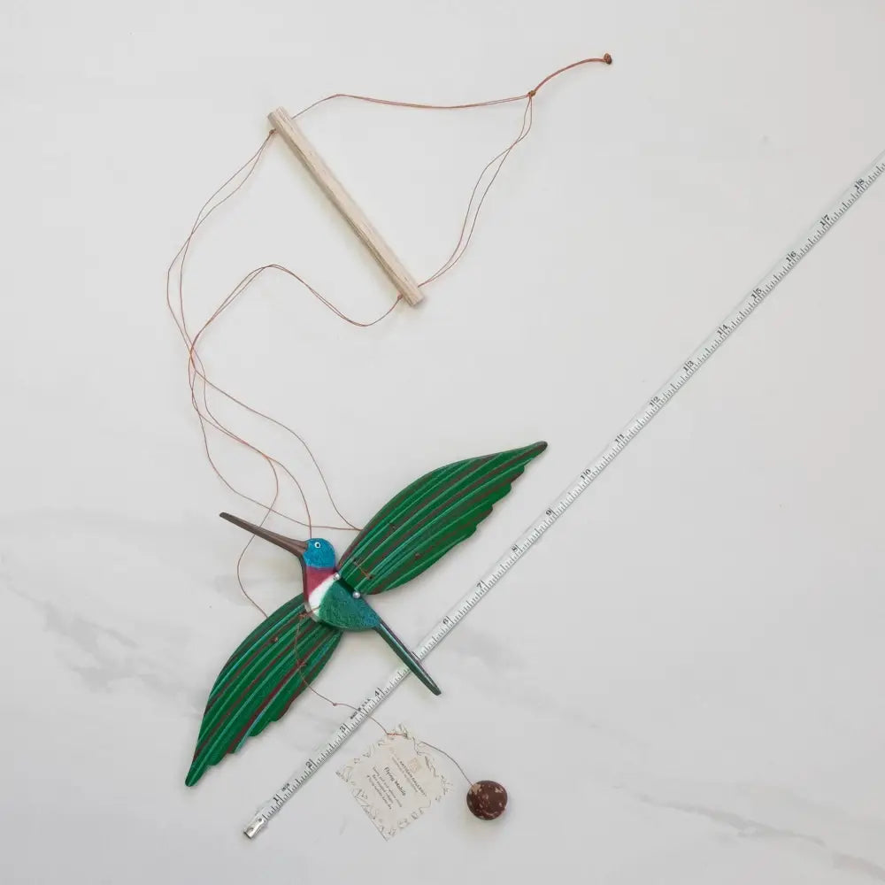 Handmade hummingbird flying mobile with green wings and blue head from a woman-owned eco-friendly business
