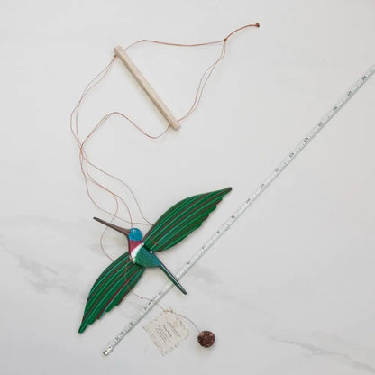 Handmade hummingbird flying mobile with green wings and blue head from a woman-owned eco-friendly business
