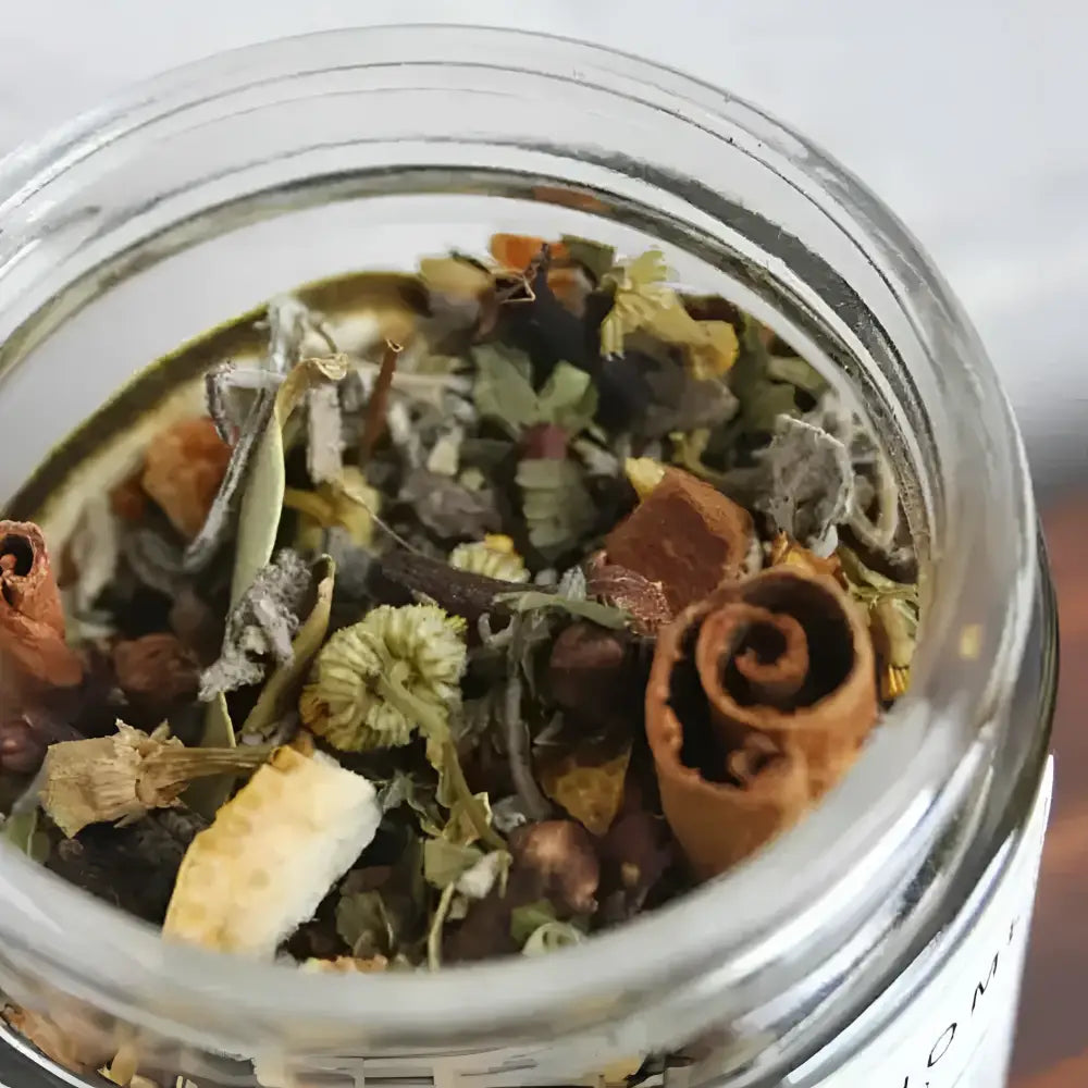 A clear glass jar of colorful dried herbs cinnamon lavender and citrus peel in immunity simmer pot blend for healthy home