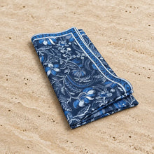 A handmade indigo blue cotton napkin with floral paisley pattern and decorative border, set of 4 pocket squares