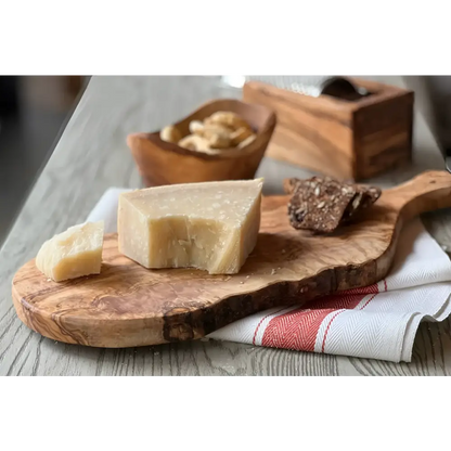 Italian Olivewood Charcuterie and Cheese Paddle Board with food on it