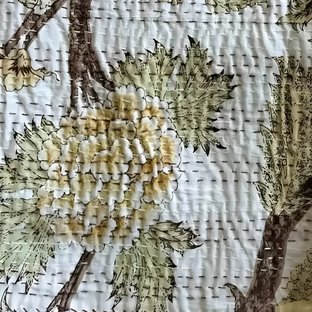 A traditional Indian kantha quilt with tree designs.