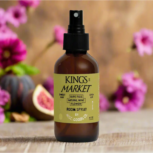 Kings Market Room Spray –bottle on wood surface with flowers in background