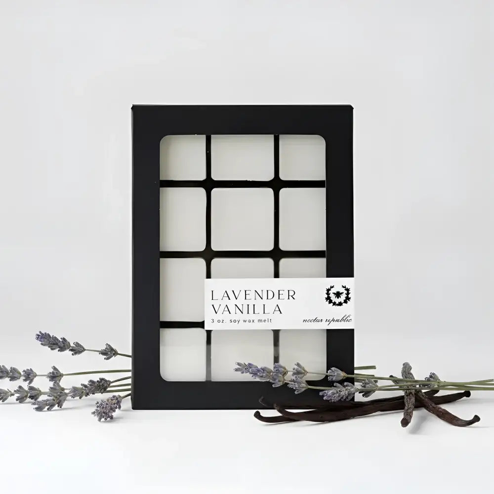 Lavender vanilla wax melts in a black grid box with white labels featuring warm vanilla beans and french lavender scent