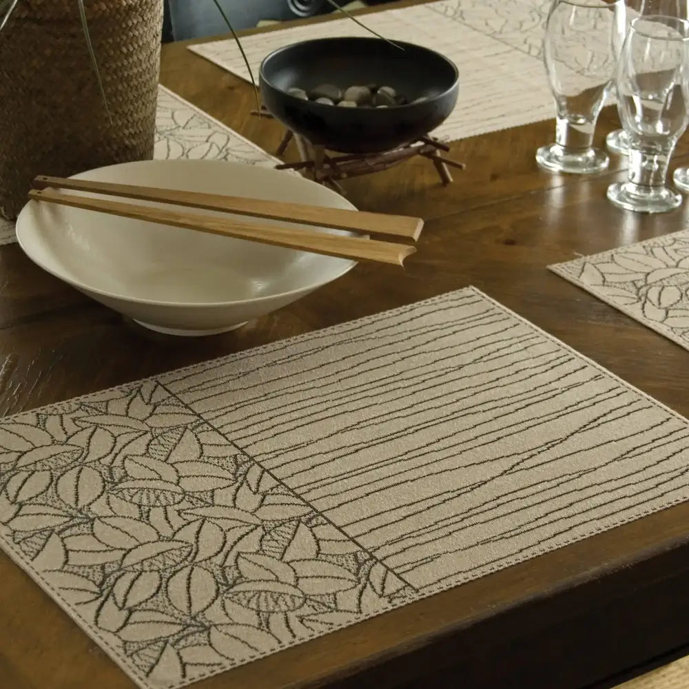 Natural color placemat with lines and leaves pattern in charcoal.