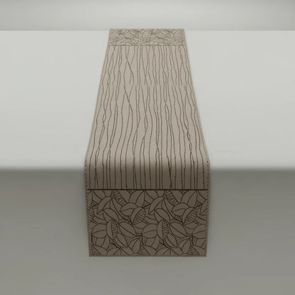 Beige woven table runner with abstract leaf and line patterns in neutral tones