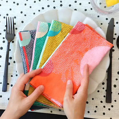 Leaf Nest linen napkin set with vibrant orange patterned napkin