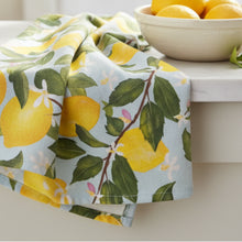 A bright lemon tea towel with vibrant yellow lemons and green leaves on soft pure cotton fabric for kitchen decor