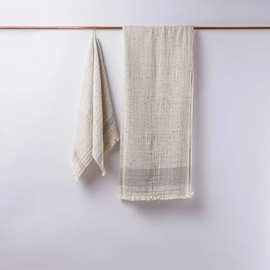 Textured off-white linen towels hanging on copper rod, perfect as double-layered muslin bath towels in Cotton Nope Yarn