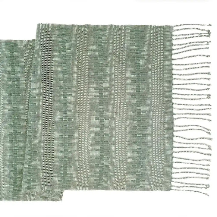 Table runner featuring sage green threads handwoven together in an intricate open weave technique called Calado.