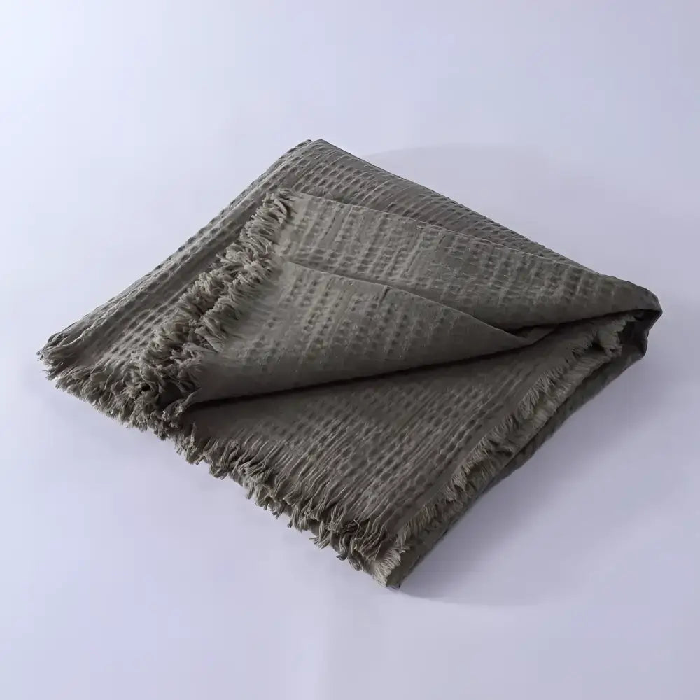 Olive green lightweight Cotton Blanket folded on light background