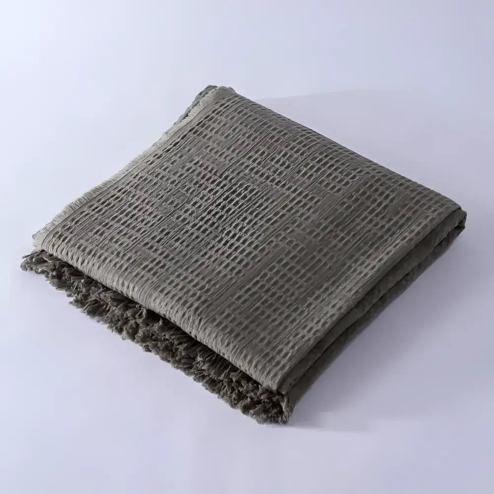 Olive green colored blanket folded on light background