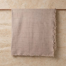 Beige lightweight handwoven cotton blanket with textured fabric and frayed edges perfect for cozy use