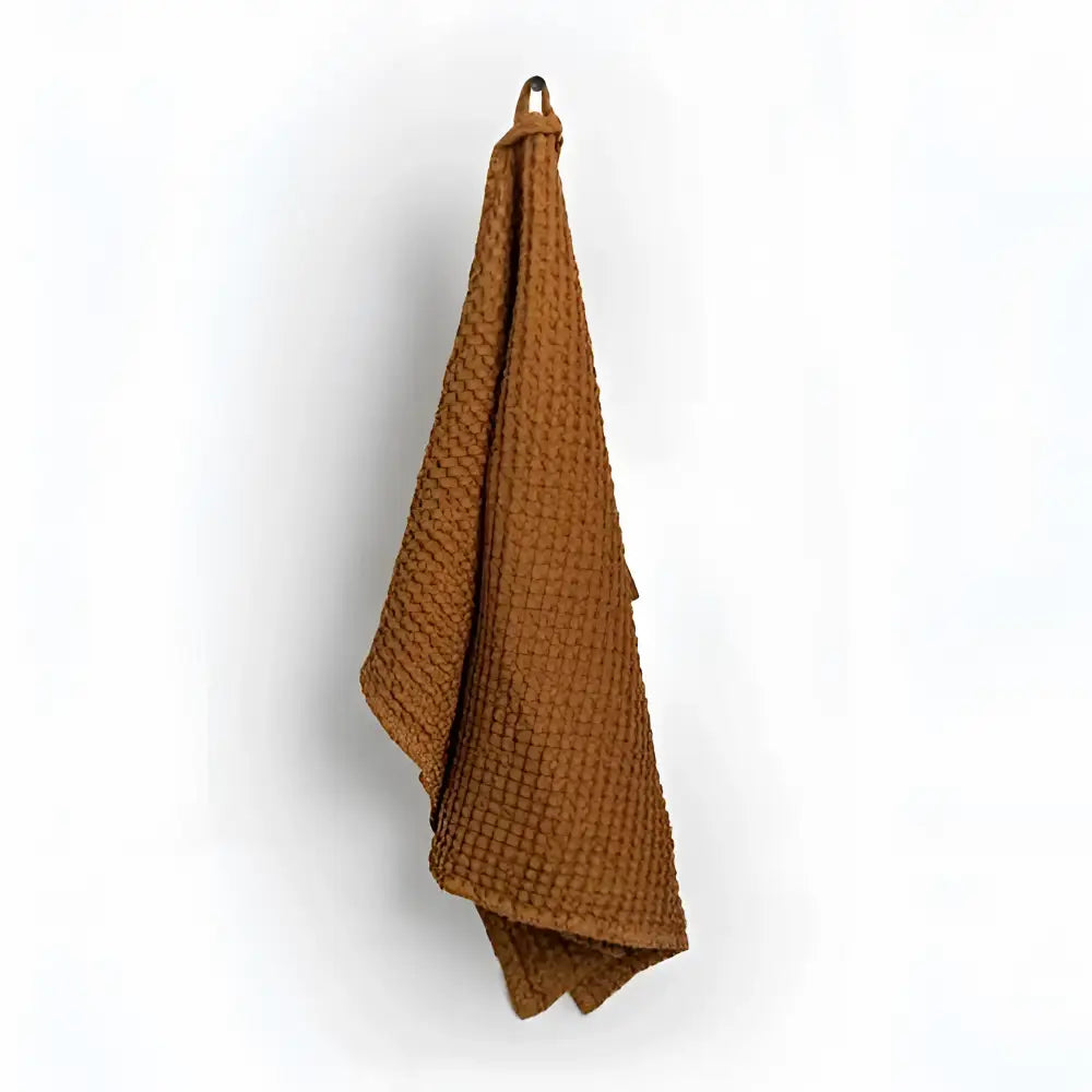Cinnamon colored linen-cotton blend waffle towel with a hanging loop.