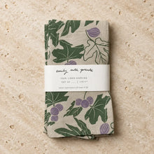 A set of beige linen napkins with fig designs and green leaves featuring hand carved stamp designs by emily with prints