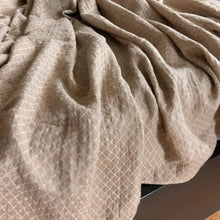 Linen throw blanket with an elegant diamond quilted design in beige and off-white tones.