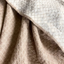 Linen throw blanket with an elegant diamond quilted design in beige and off-white tones.