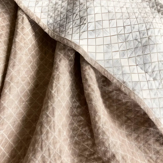 Linen throw blanket with an elegant diamond quilted design in beige and off-white tones.