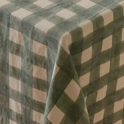 Fabric covering on wood table with green checkered pattern.