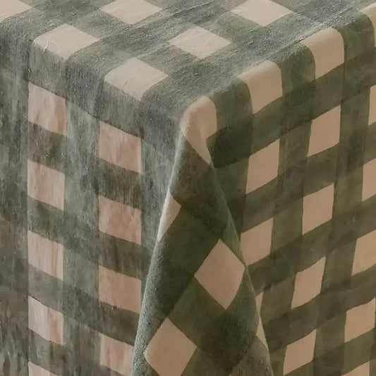 Fabric covering on wood table with green checkered pattern.