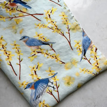 Fabric with blue birds and yellow flowers on a light blue background