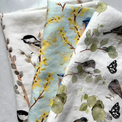 Set of three towels with nature-themed patterns on a light background