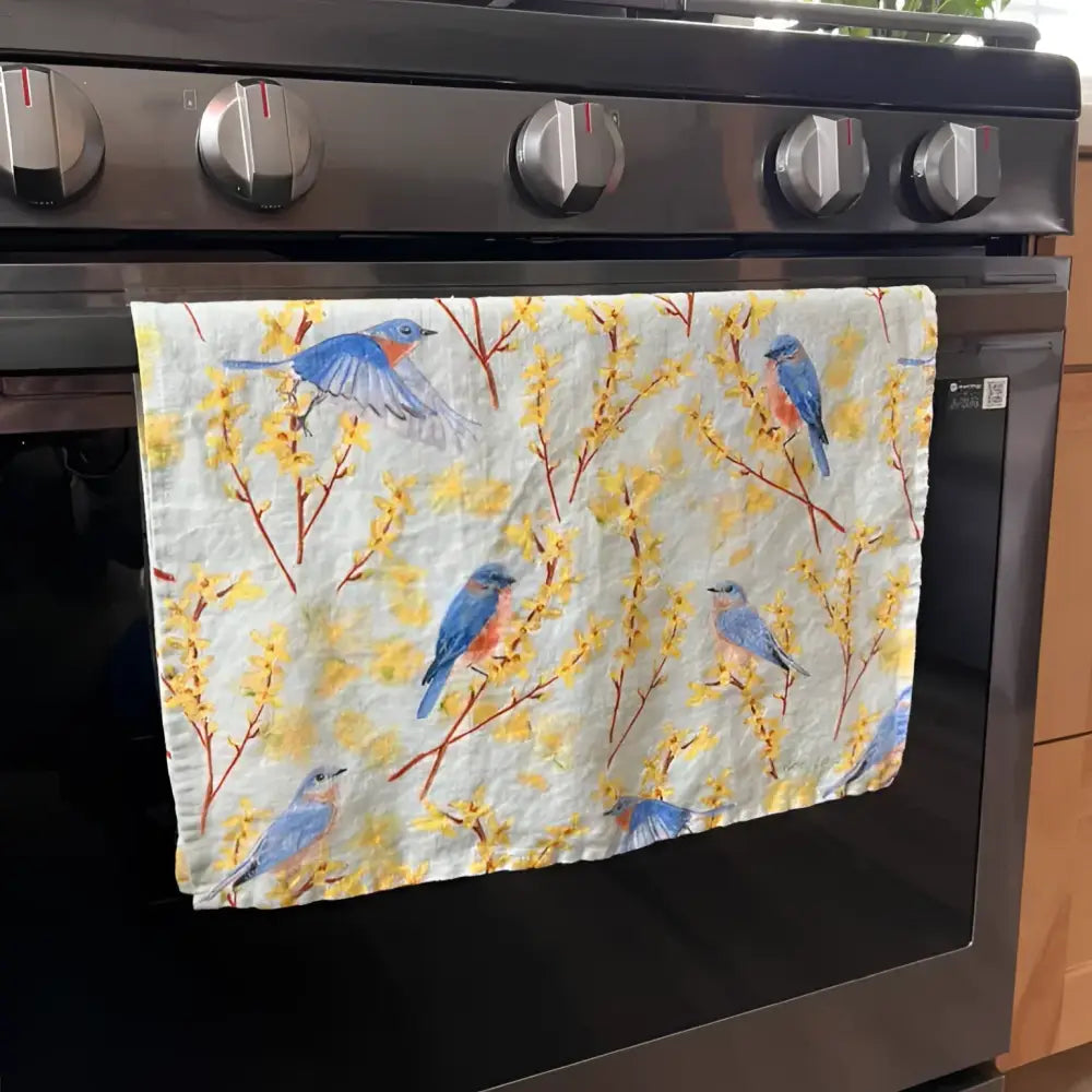Decorative towel with bluebird design on a Samsung oven