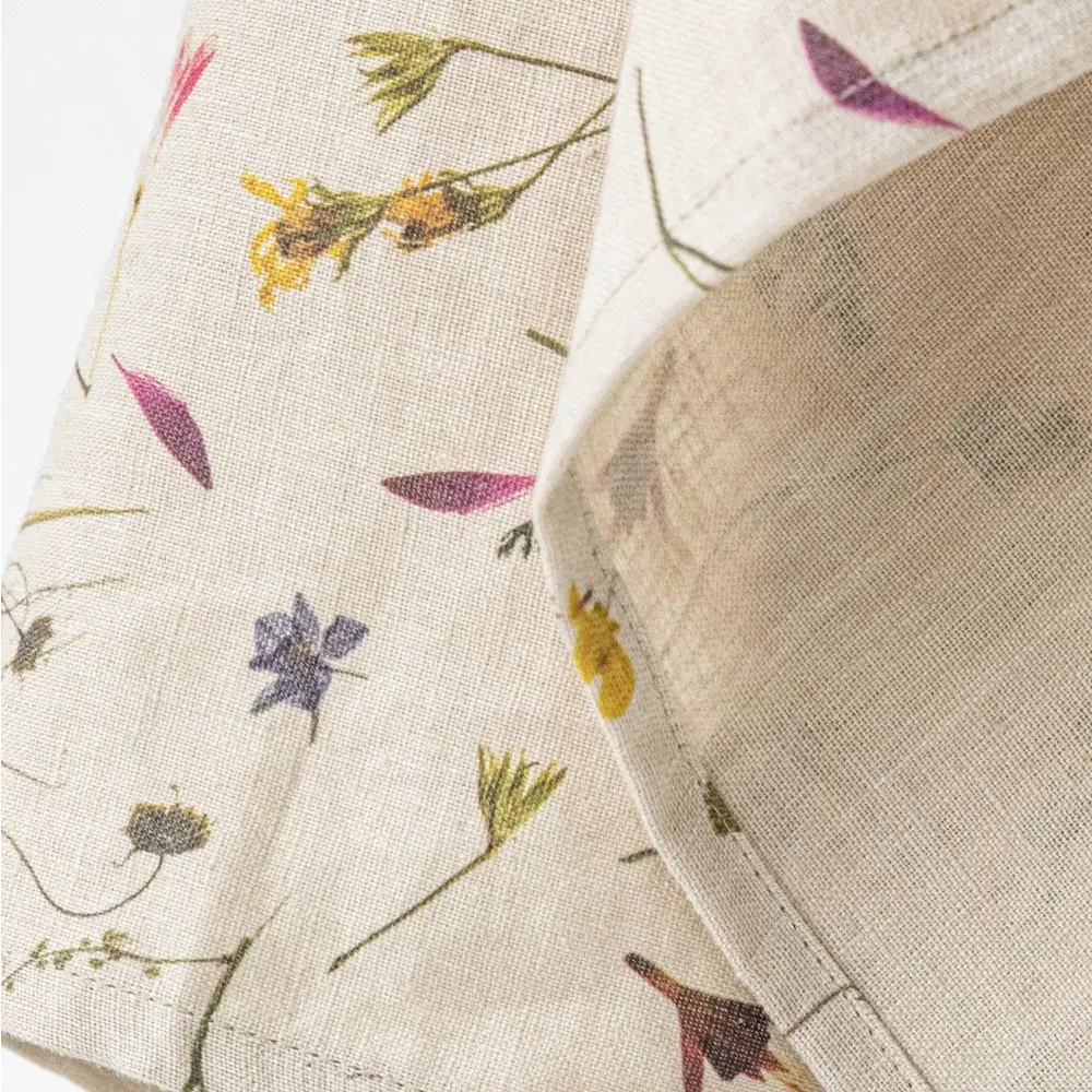 100% Linen tea towel with a natural base color and embellished with botanical prints inspired by pressed flowers. 