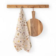 100% Linen tea towel with a natural base color and embellished with botanical prints inspired by pressed flowers. 