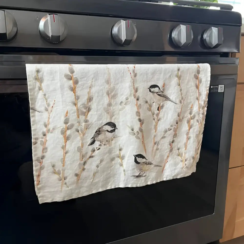 Towel with bird design hanging on a Samsung oven