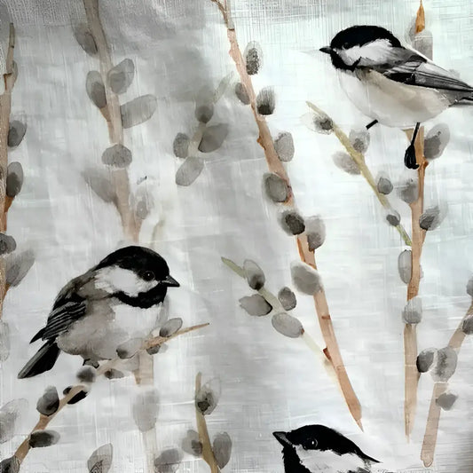 Fabric with bird and branch pattern and a wooden rolling pin on a light background