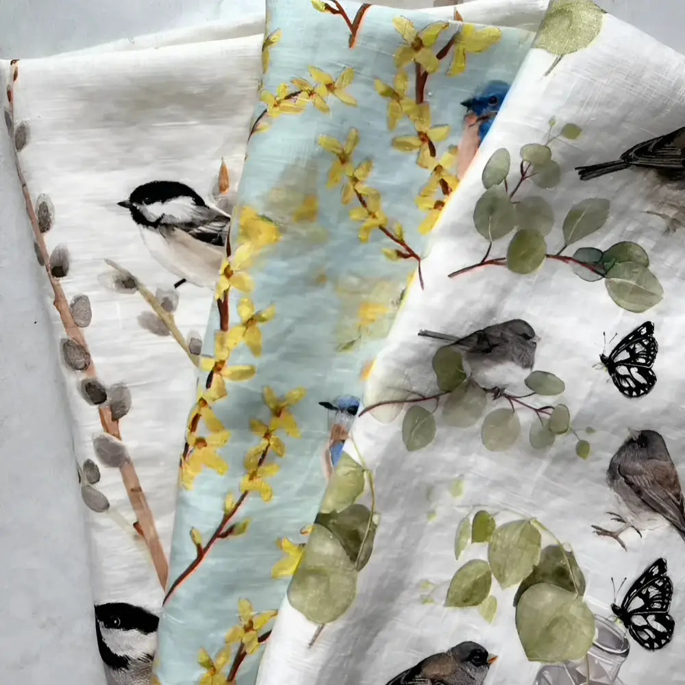 Set of three towels with nature-themed patterns on a light gray background