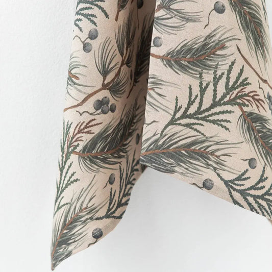 This linen tea towel features a natural colored base with a design print of evergreen foliage and berries.