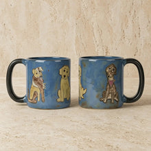 Blue stoneware mugs with black handles hand painted with cartoon dogs by mara ceramica artisans in mexico
