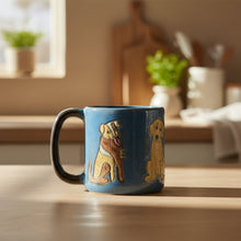 Handcrafted blue ceramic mug with black handle and three yellow brown dogs