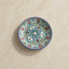 Hand-painted amira ceramic bowl with vibrant mandala-like floral patterns in teal blue green and terracotta with cobalt rim