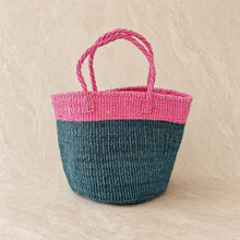 Medium sisal tote handwoven by skilled weavers in africa with vibrant pink top and handles and deep teal lower half