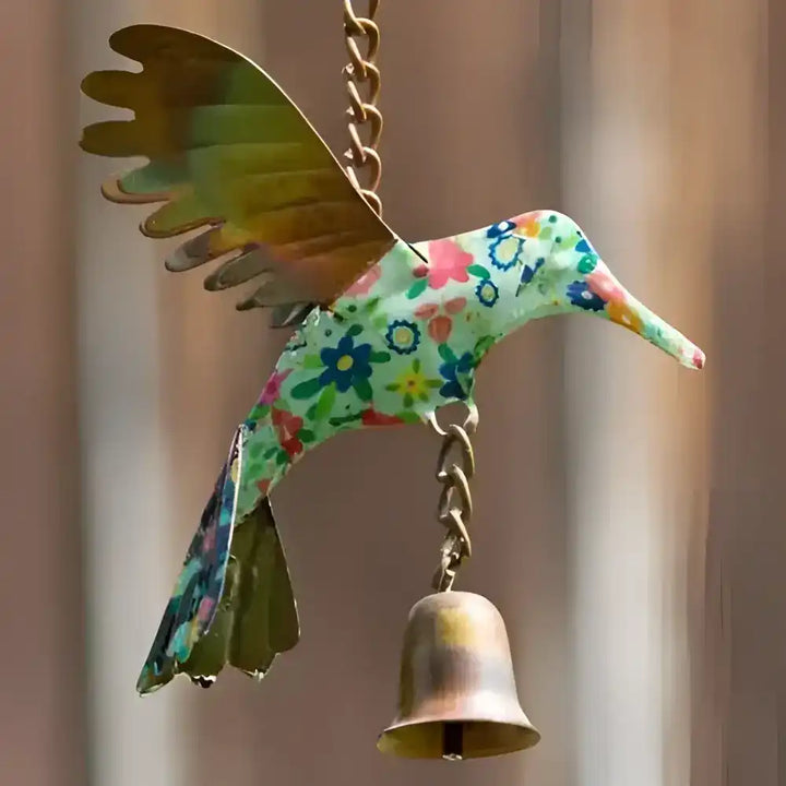 Decorative bird-shaped bell with floral pattern on a blurred background