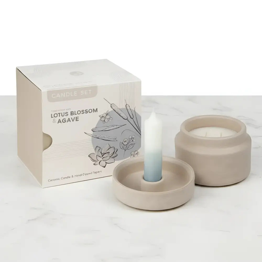A mindful moments candle set featuring a beige ceramic vessel and saucer with an ombre white to light blue taper candle